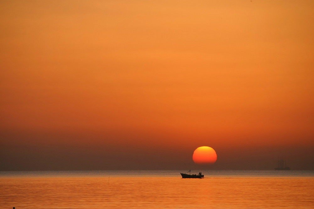 Sonnenuntergang oder Sonnenaufgang mit Boot, Meer