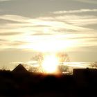 Sonnenuntergang über den Häusern vorm Wald III