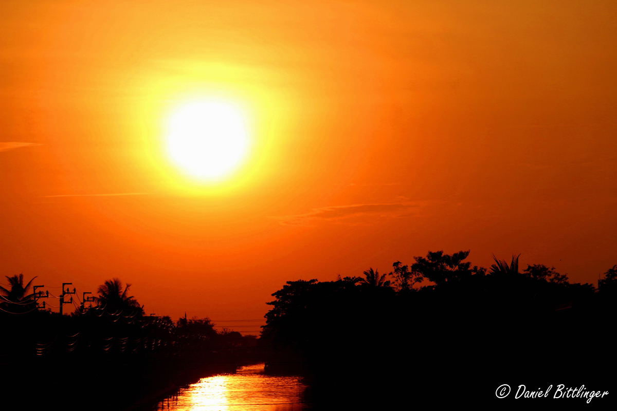 Sonnenuntergang über einem Fluss in Thailand