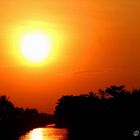 Sonnenuntergang über einem Fluss in Thailand