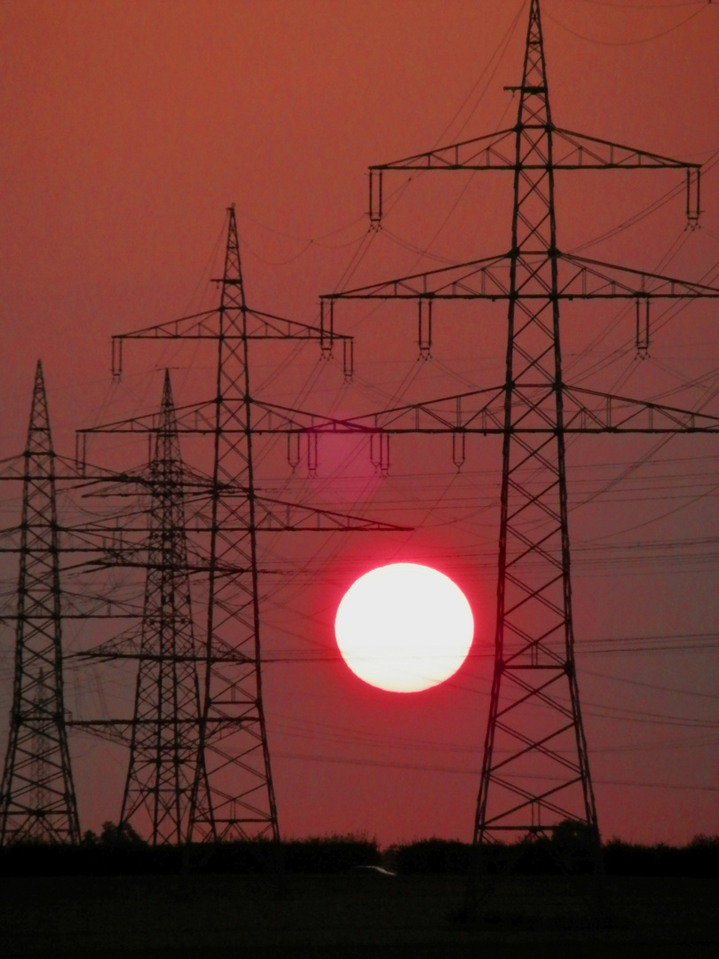 Sonnenuntergang zwischen Hochspannungsmasten