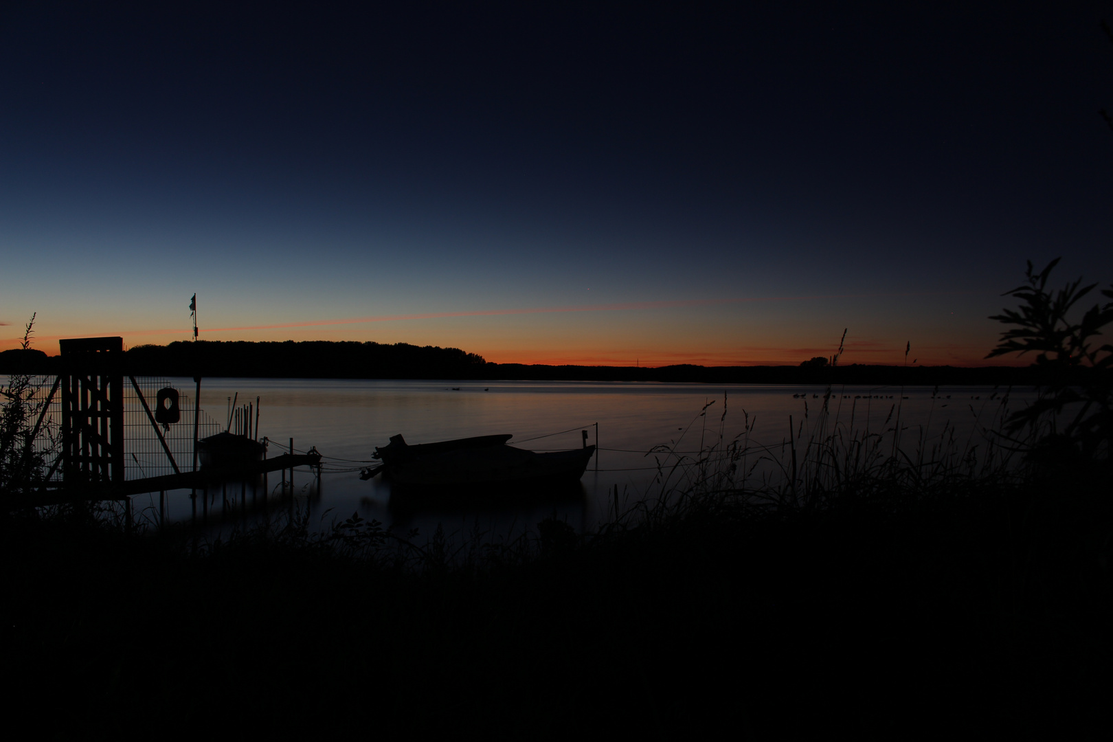 Sonnenuntergang/Blaue Stunde am Binnenwasser mit Booten im Vordergrund