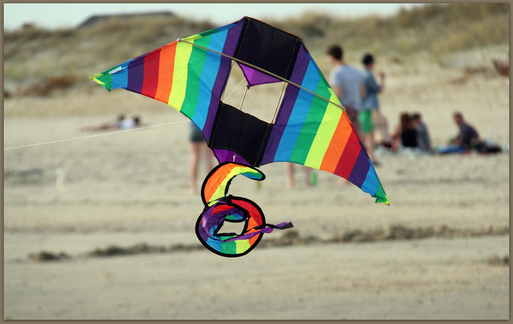 Spaß am Strand beim Drachen steigen lassen oder chillen