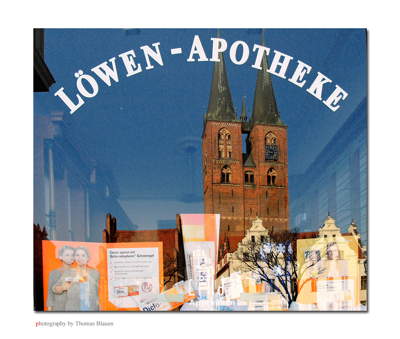 Spiegelbild der Marienkirche & Rathaus im Fenster der Löwenapotheke in Stendal