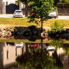 Spiegeltag - rotes Auto am Fluss