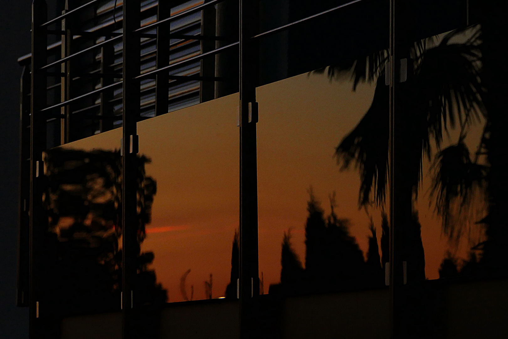 Spiegelung der Abendstimmung in der Balkonumrandung