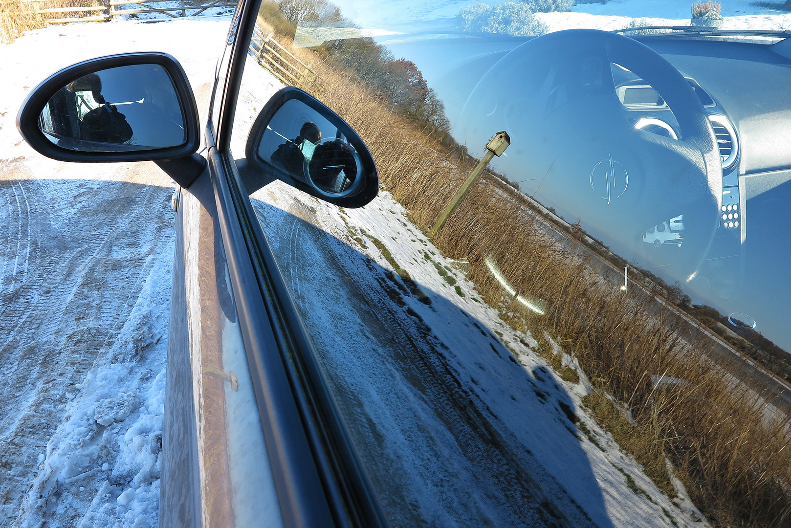 Spiegelung der Winterlandschaft in der Auto-Fensterscheibe