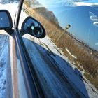 Spiegelung der Winterlandschaft in der Auto-Fensterscheibe