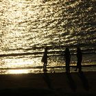 Spielende Kinder am Strand in der Abenddämmerung.