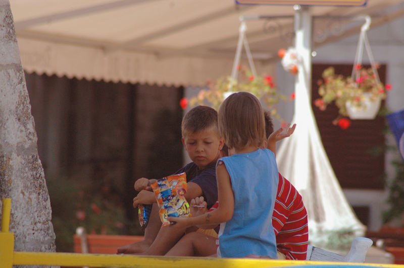 Spielende Kinder im Schatten eines Kirchturmes.