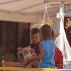 Spielende Kinder im Schatten eines Kirchturmes.