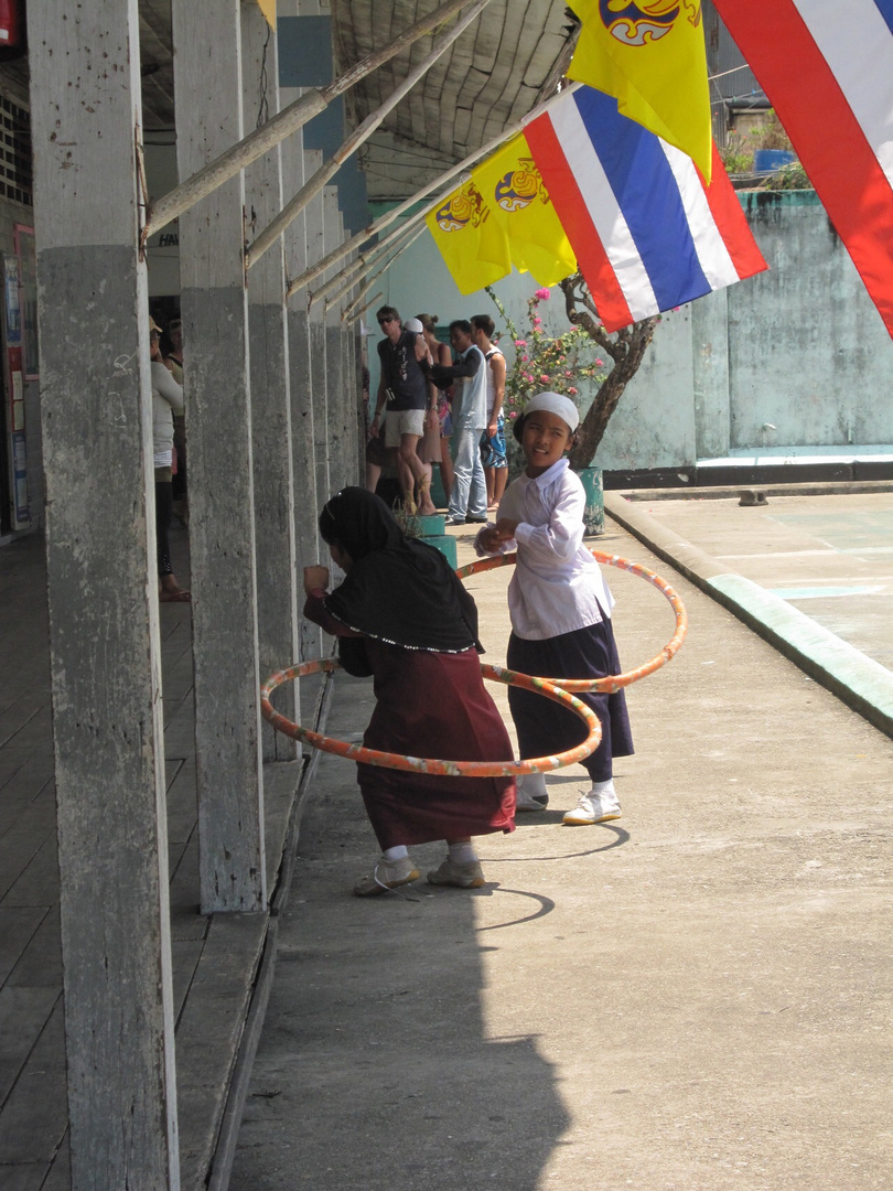 Spielende Kinder in einem thailändischen Wasserdorf