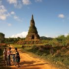 Spielende Kinder vor einer Stupa in der Nähe von Phonsavan