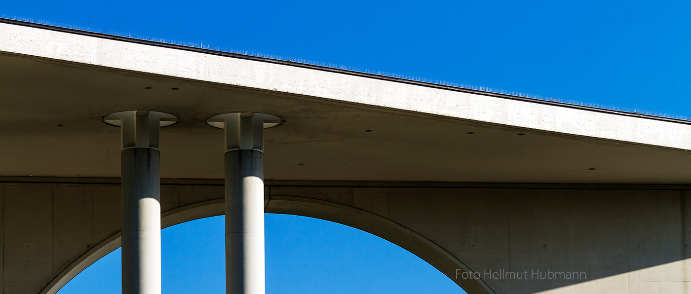 SPIELEREI FÜR BLICK NACH OBEN MIT BETON UND BLAUEM HIMMEL