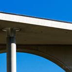 SPIELEREI FÜR BLICK NACH OBEN MIT BETON UND BLAUEM HIMMEL