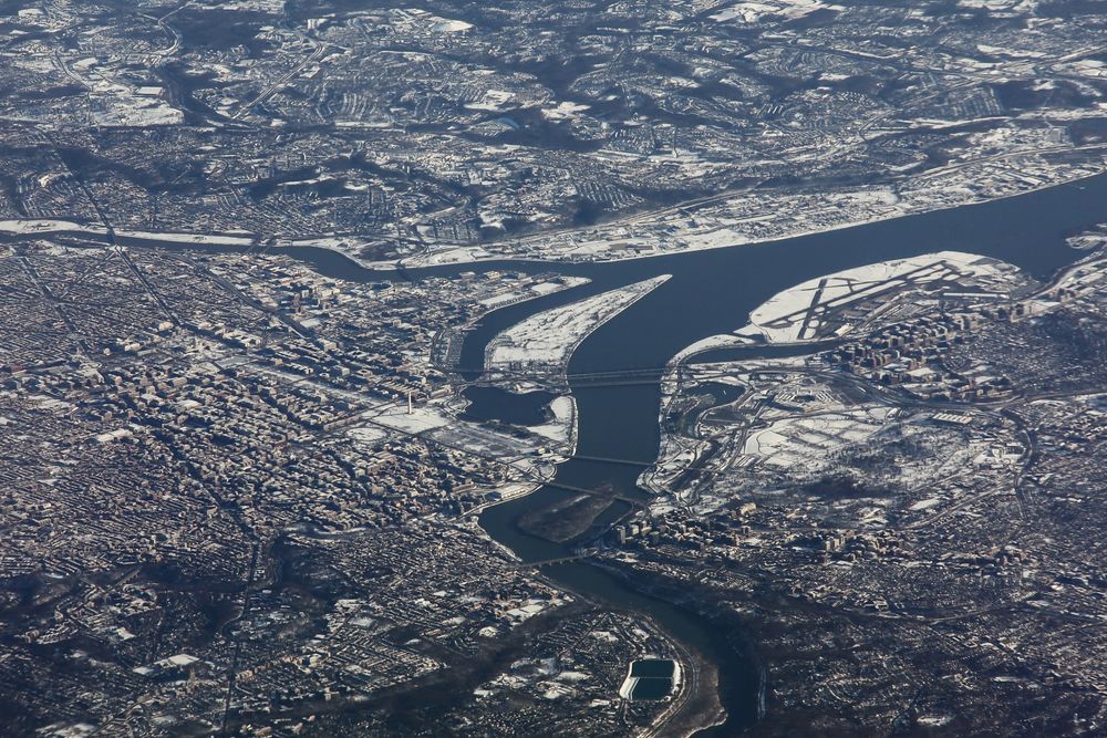 Stadt im Schnee am kalten Fluß.