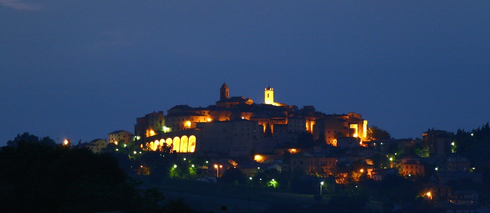 Stadt mit Abendbeleuchtung in der Marche