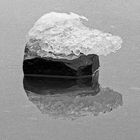 Stein mit Eishaube im Wasser