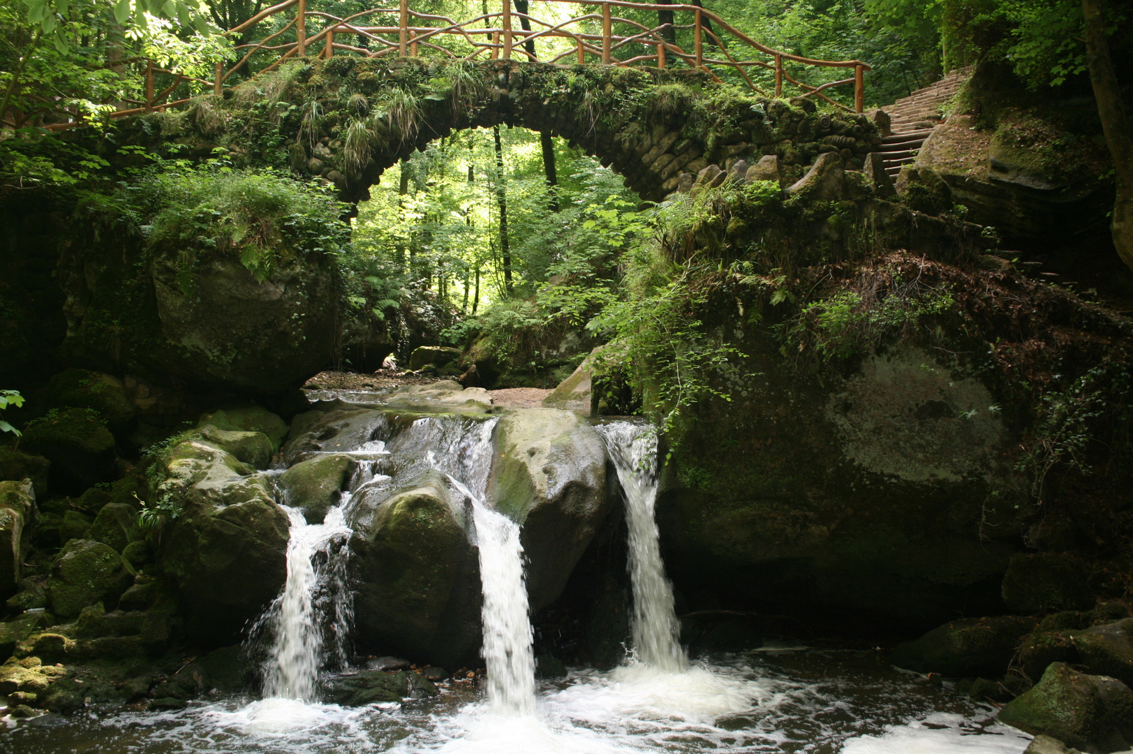 Steinbrücke über kleinem Wasserfall