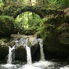 Steinbrücke über kleinem Wasserfall