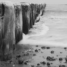 Steine an Holz mit Wasser im Sand