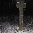 Steinkreuz bei abendlichem Schneefall