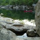 Steinmulde mit meinem Sohn im Kanu in der Ardéche im Hintergrund