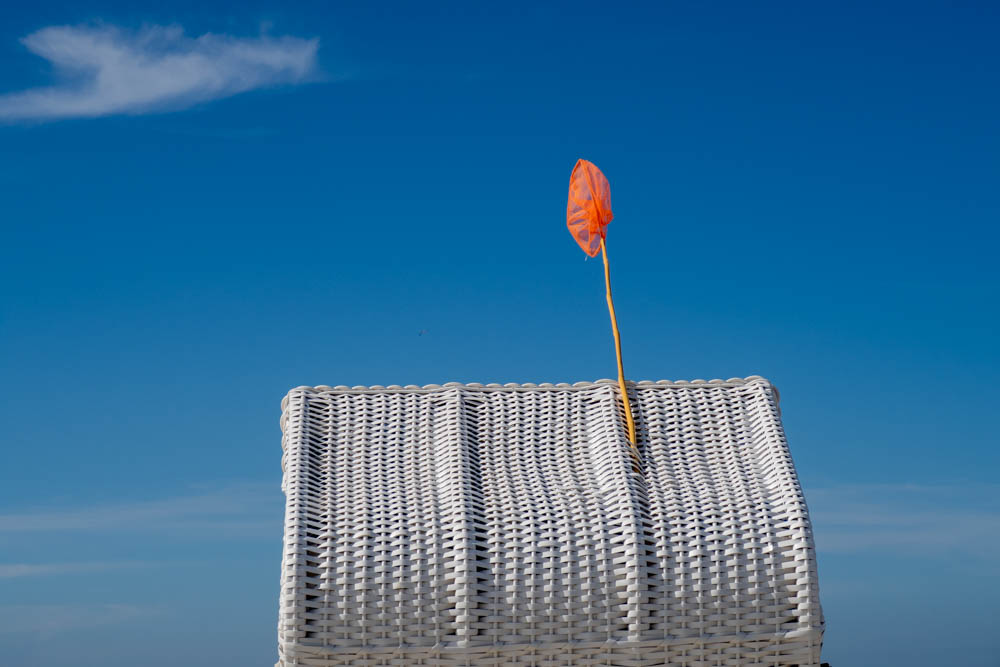 Stilleben mit Strandkorb, Kescher und Flugzeug