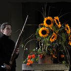 Stillleben mit Blumen, Musikerin und Barockfagott vor dem Konzert