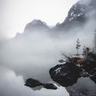 Stimmungsvoller See mit Bergen und Nebel