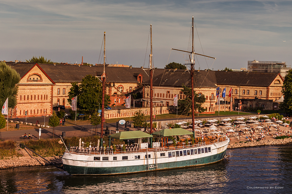 Strandleben mit Restaurantschiff zur Abendstunde am Rhein