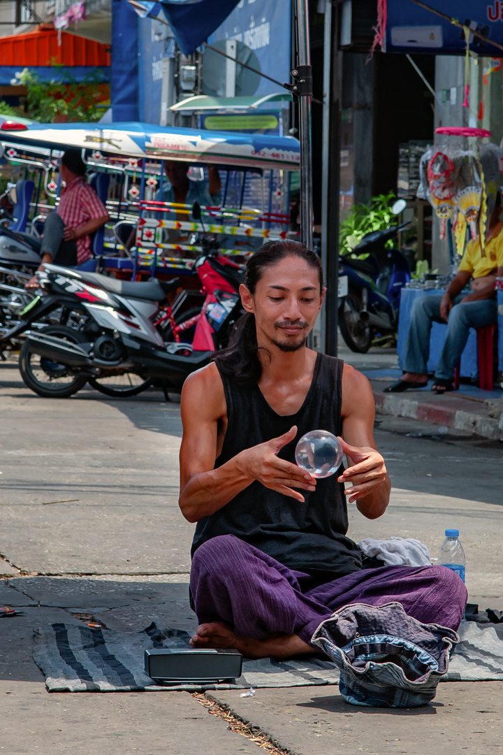 Street artist juggle with a glas ball 