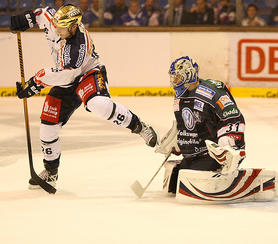 Stürmer Florian Busch (Eisbären) und Torhüter Adam Hauser (Huskies)