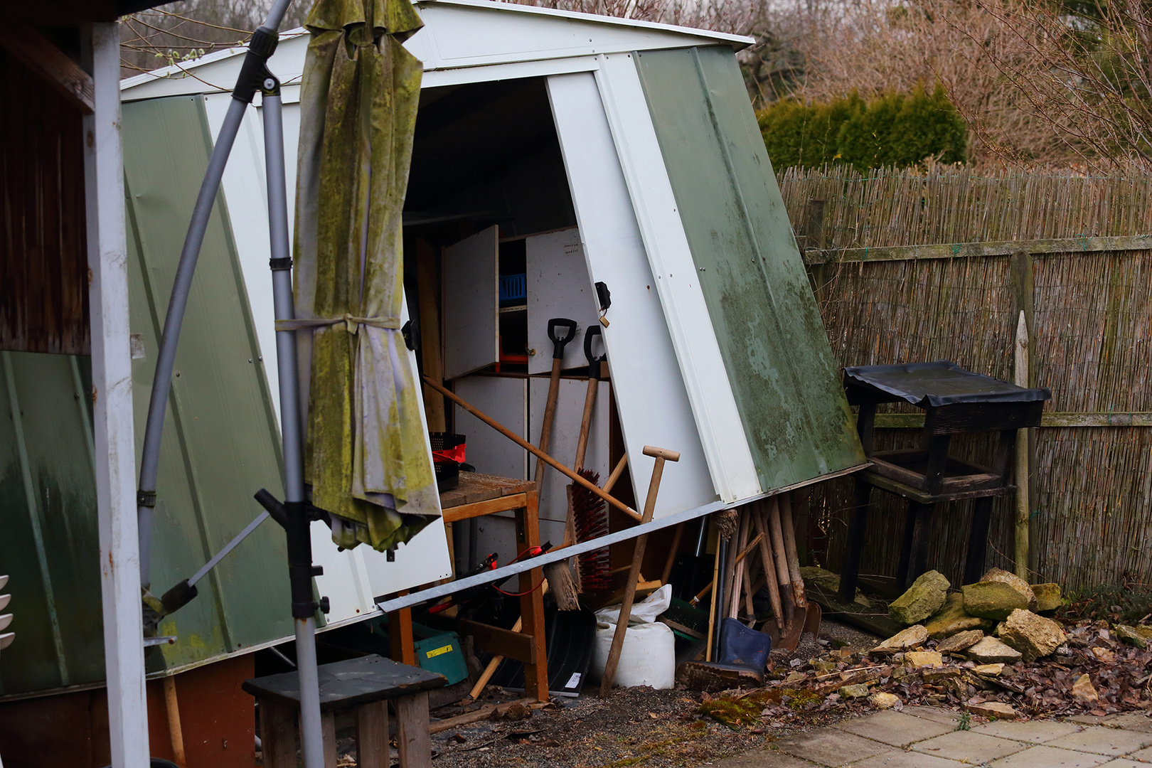 Sturm und Orkanschäden im Garten mit einem Blechschuppen und...