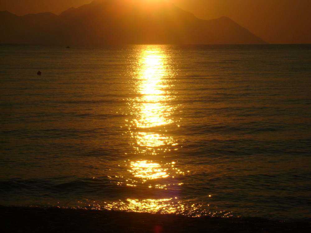 sun having a bath in the sea under the Athos mountain