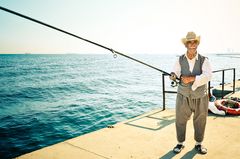 sunny old boy with big fishing rod