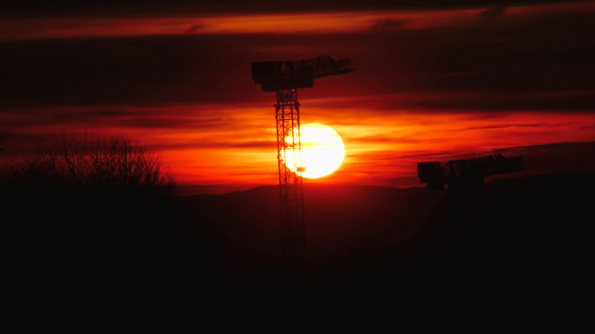 Sunset behind cranes