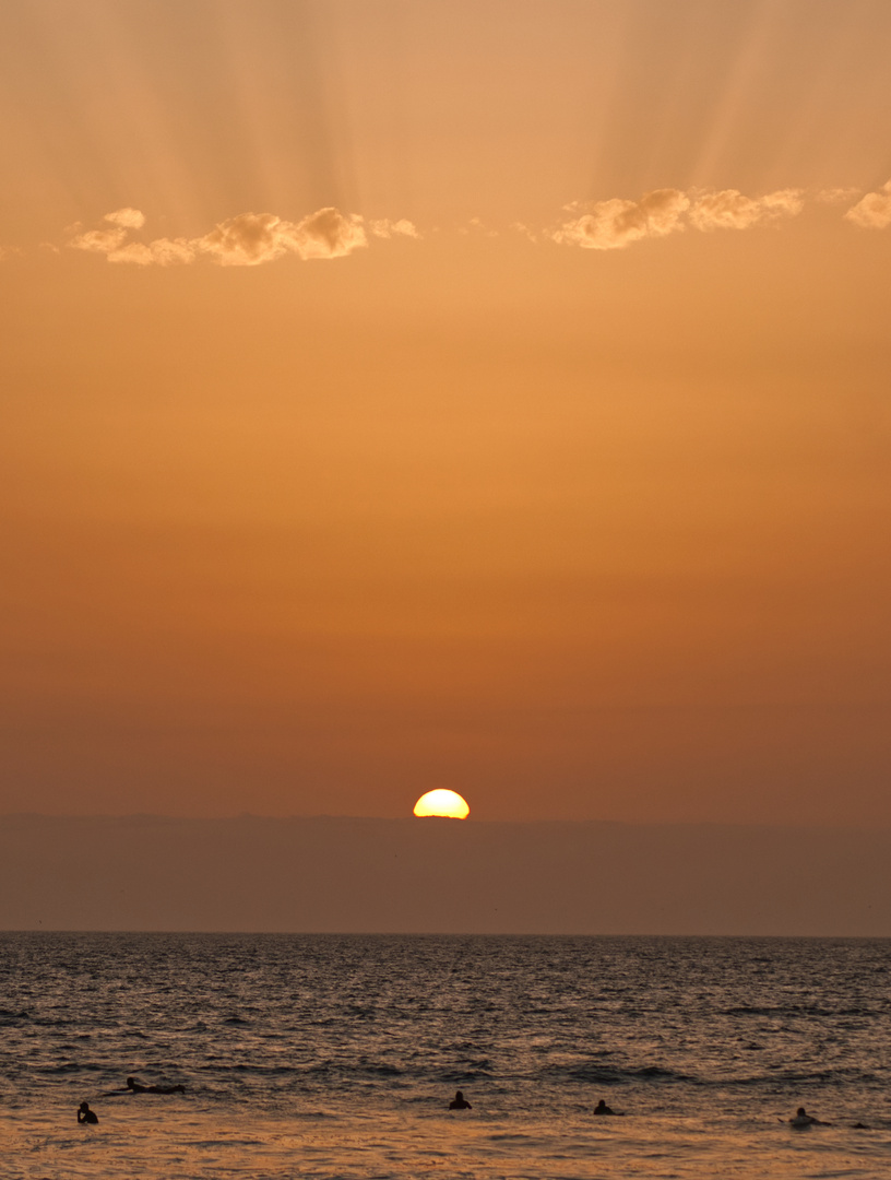 Surfer auf dem Ozean mit dem atemberaubenden Sonnenuntergang