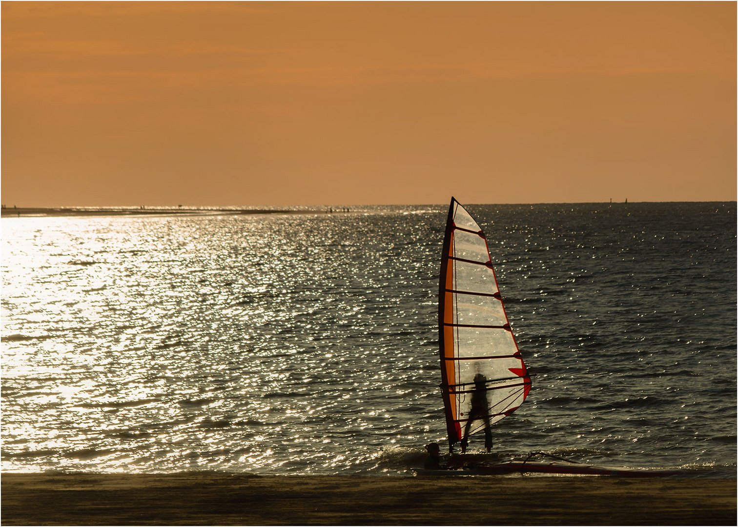 Surfer im Sonnenuntergang am Meer