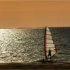 Surfer im Sonnenuntergang am Meer