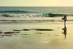 Surfers try to ride small waves in Canggu