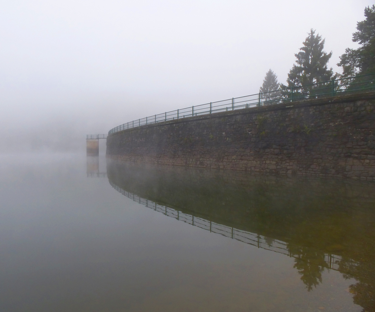 Talsperrenmauer in erstem Herbstnebel