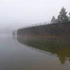 Talsperrenmauer in erstem Herbstnebel