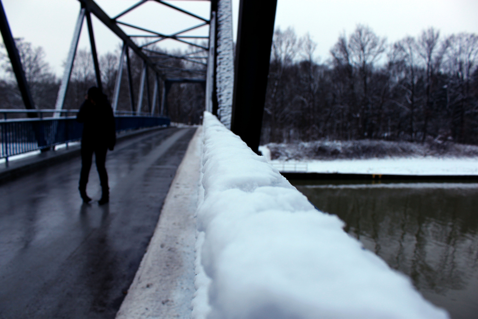 Telefonieren auf der Brücke am Kanal im Winter