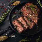 Tender sliced sous-vide beef steak in a cast iron pan