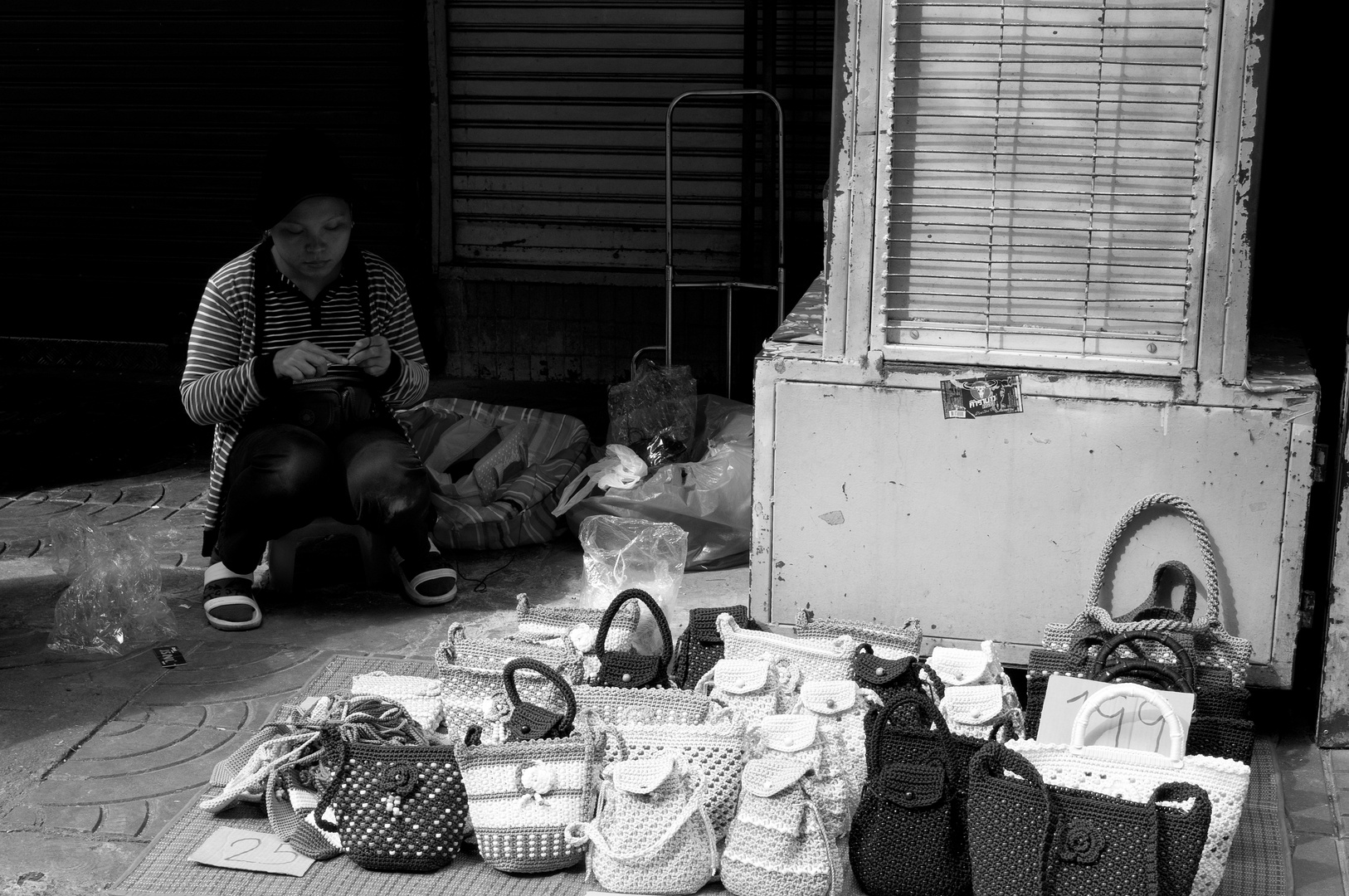 Thailänderin fertigt Taschen auf der Strasse an