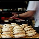 The baker removing the steaming hot Pita bread from the oven at amazing speed!