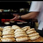 The baker removing the steaming hot Pita bread from the oven at amazing speed!