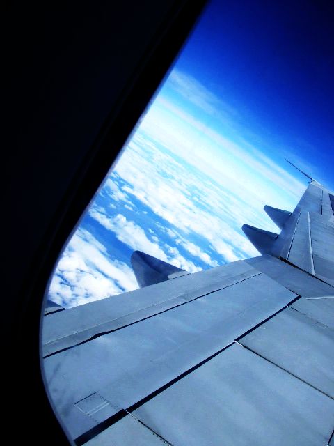 The beautiful sky outside a plane window.