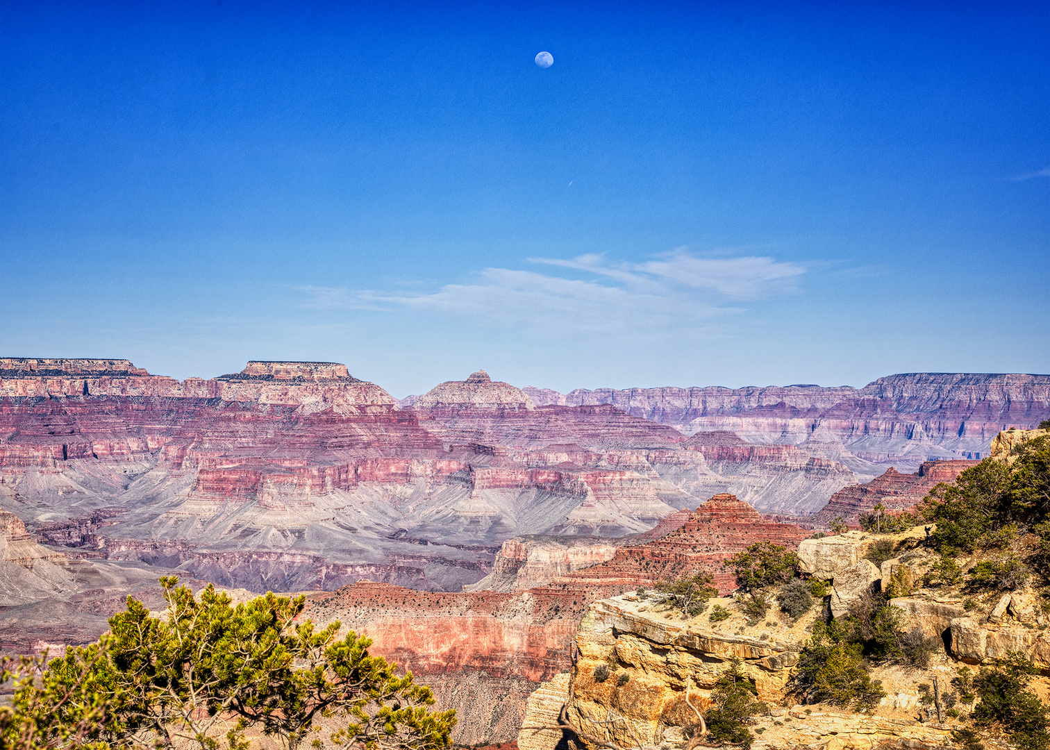 The moon looks over the Grand Canyon